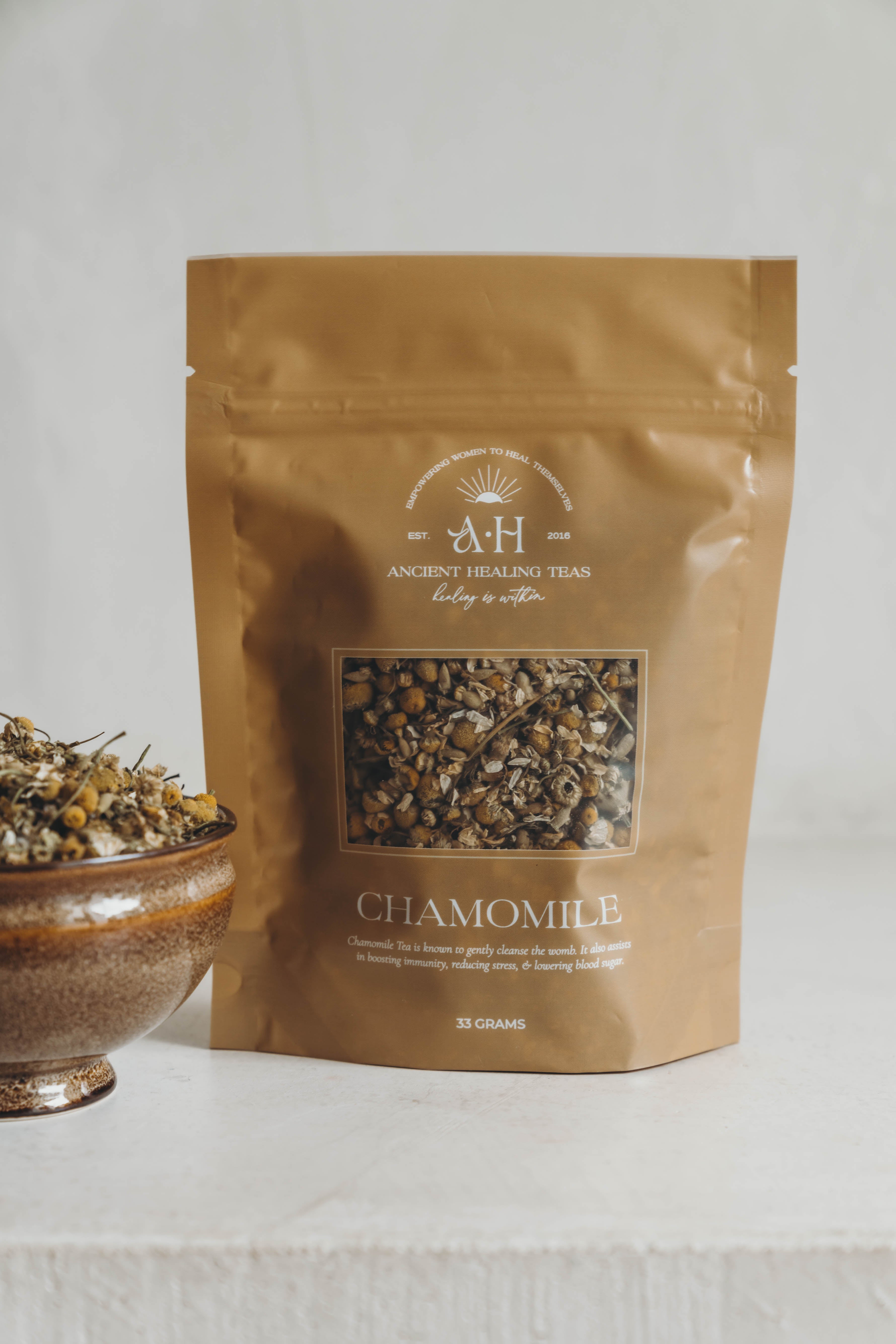 Brown package of chamomile tea with a bowl of dried chamomile flowers on a light background. Additional Benefits:
Eases anxiety
Improves sleep quality
Promotes a more calm, relaxed state
Boosts the immune system
Directions:
Bring 12 oz of water to a boil & add one teaspoon of Chamomile Tea.