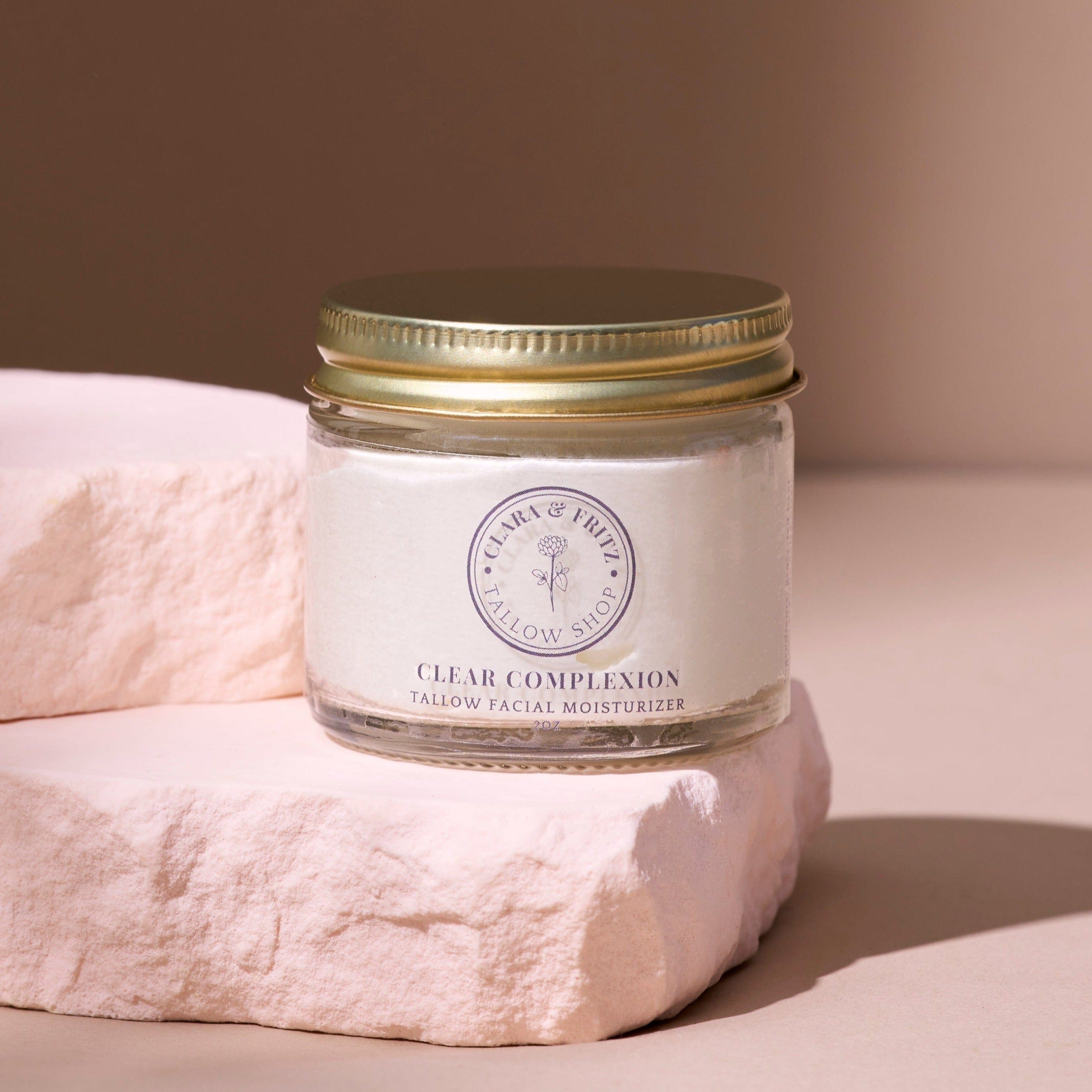 Jar of 'Clear Complexion' facial moisturizer on a beige background. 100% grass-fed beef tallow, *extra virgin olive oil, geranium bourbon oil, pink grapefruit oil, himalayan cedarwood oil, peppermint oil, rosemary oil, roman chamomile oil; *certified organic
Clear Complexion is petroleum free, paraben-free and contains no dyes or artificial fragrances. It is safe for use on sensitive skin, and can be used daily to help prevent breakouts. 