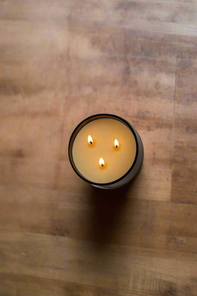 Three-wick candle in a black holder on a wooden surface.
Hand-poured in Austin, Texas, this candle is made with 100% soy wax and pure essential oils