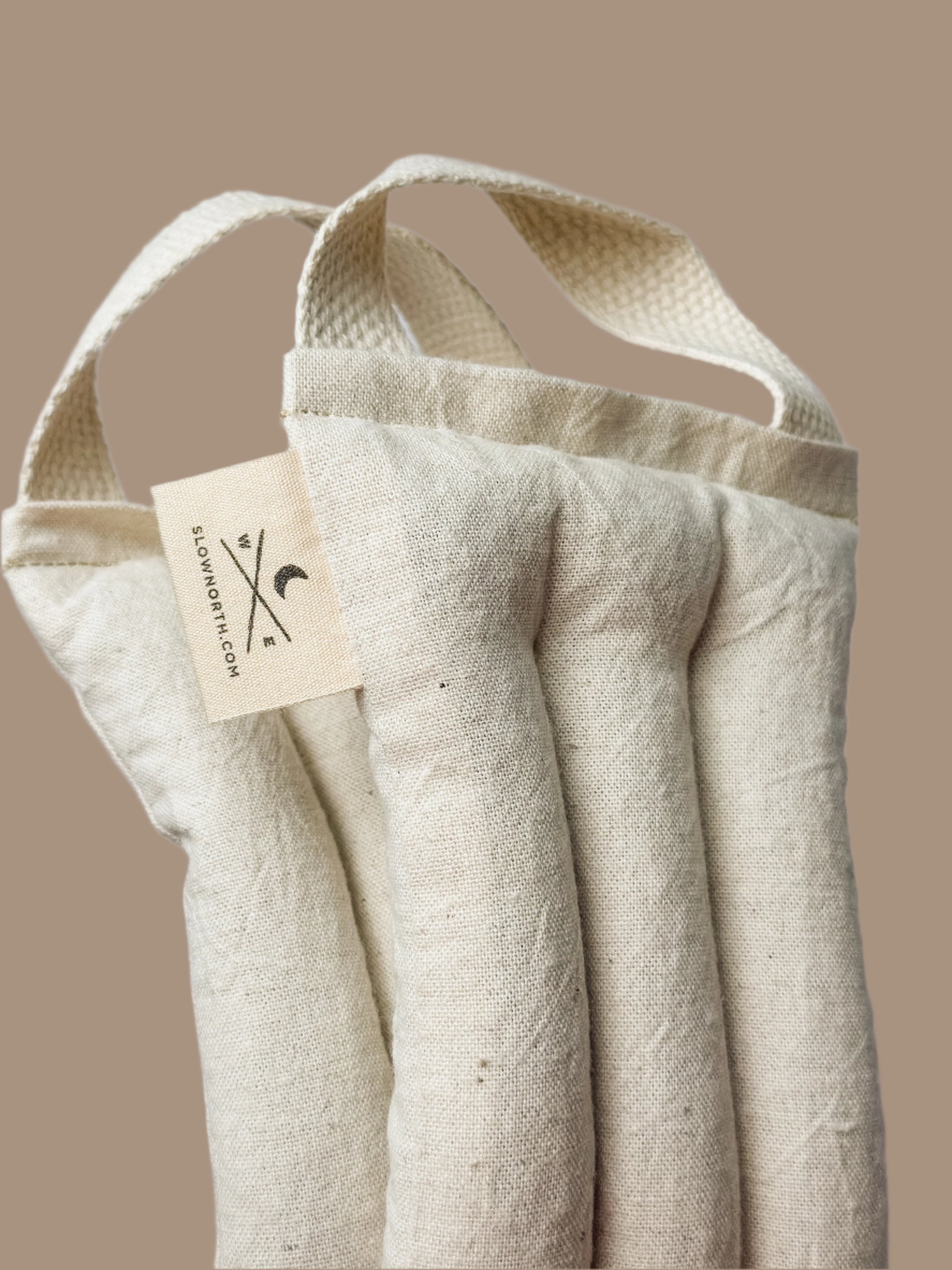 Beige fabric bag with a tag on a beige background. A natural linen and cotton weighted neck wrap to ease the stress away.
Melt away the tension: Let this cheerful therapy pack melt away the aches and pains as it drapes around your neck and shoulders.
Relax in your own way: This well-designed therapy pack neck pillow can be applied warm or cold depending on your preference.
Soothe tension & aches: Cold and warm therapy packs can work wonders for pain.
Your answer for natural relief: Designed with your w