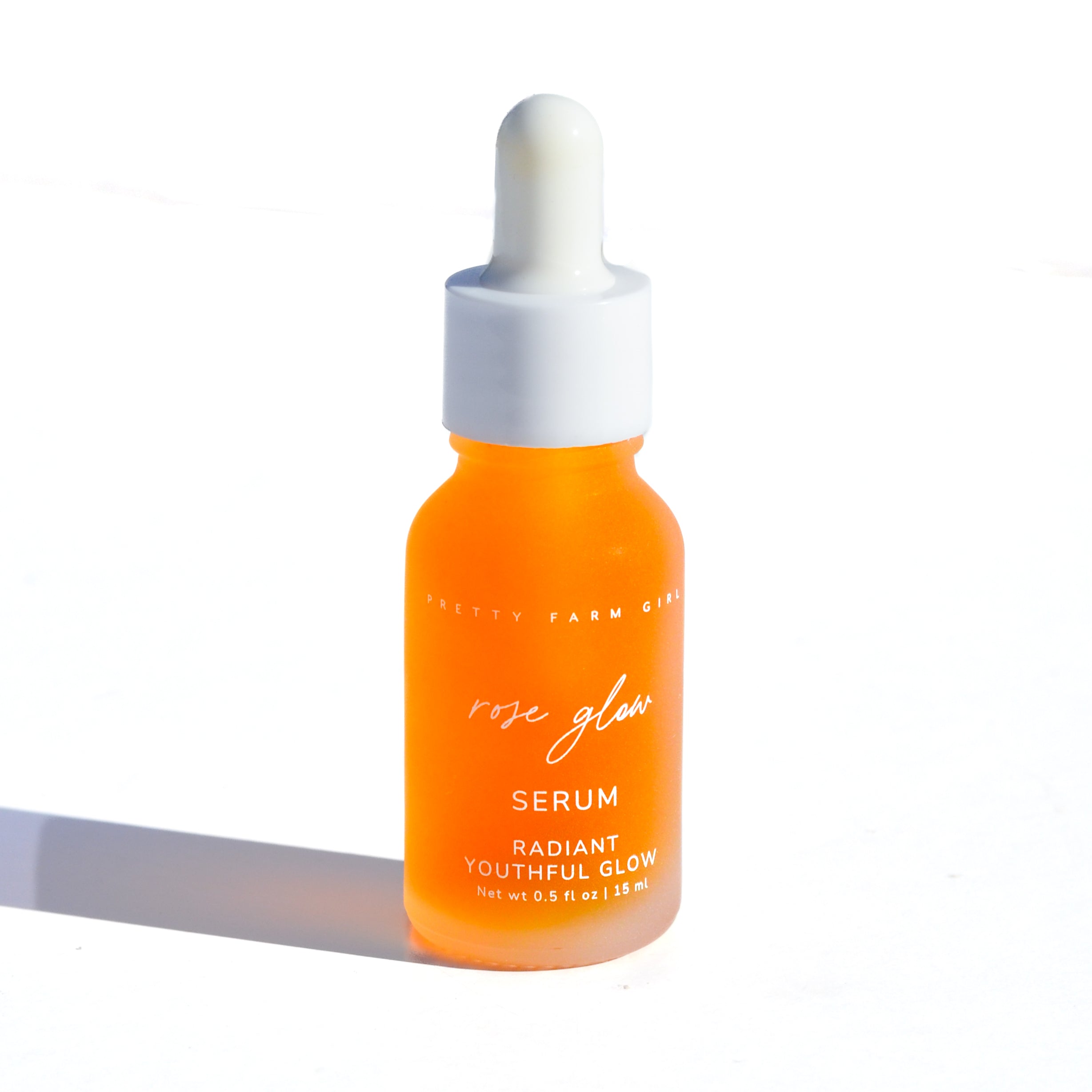Orange serum bottle with dropper on a white background. Orange bottle and jar of facial product on a white background. rosehip and rose essential oils serum and facial cleansing lotion radian youthful glow