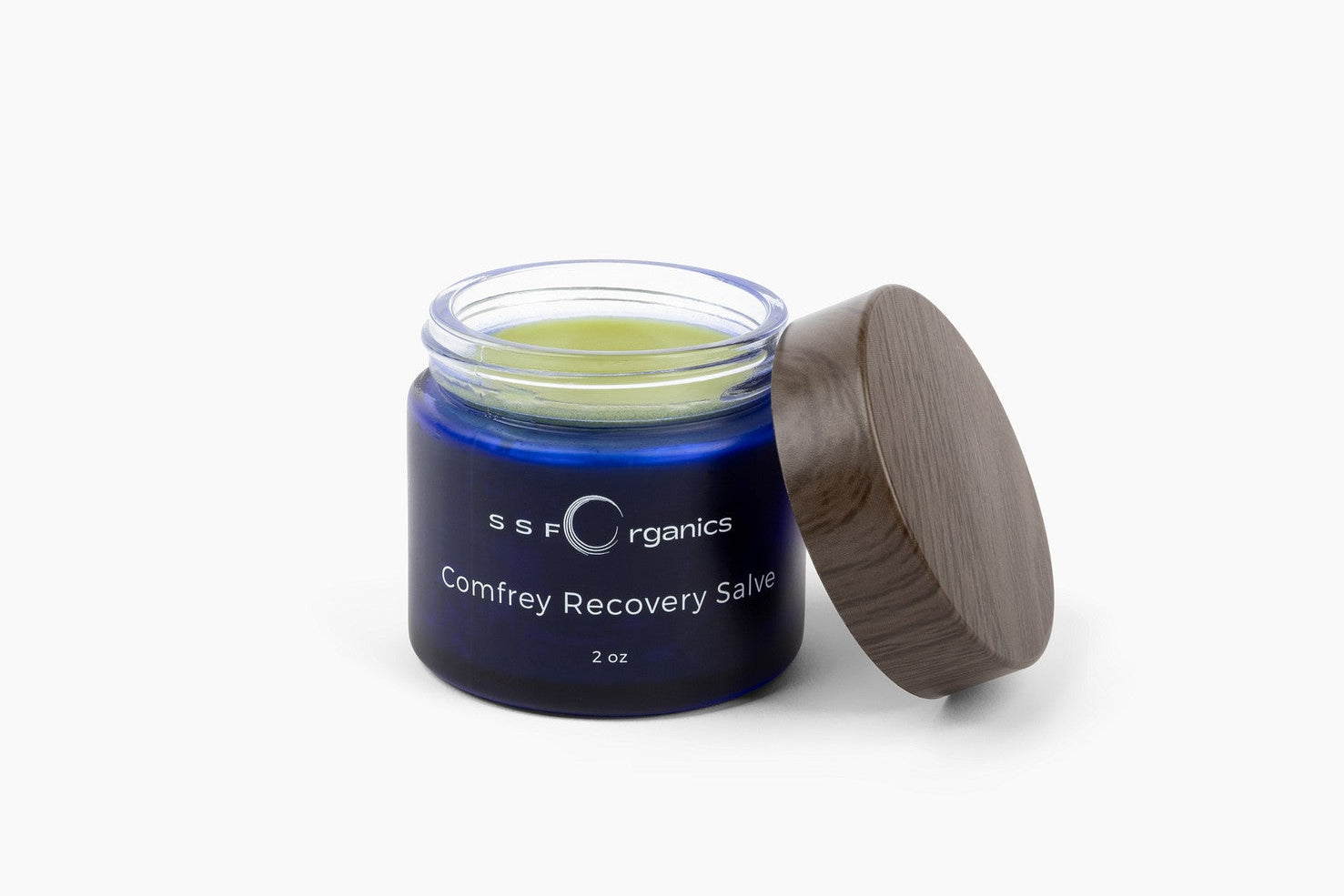 Jar of Comfrey Recovery Salve with a wooden lid on a white background