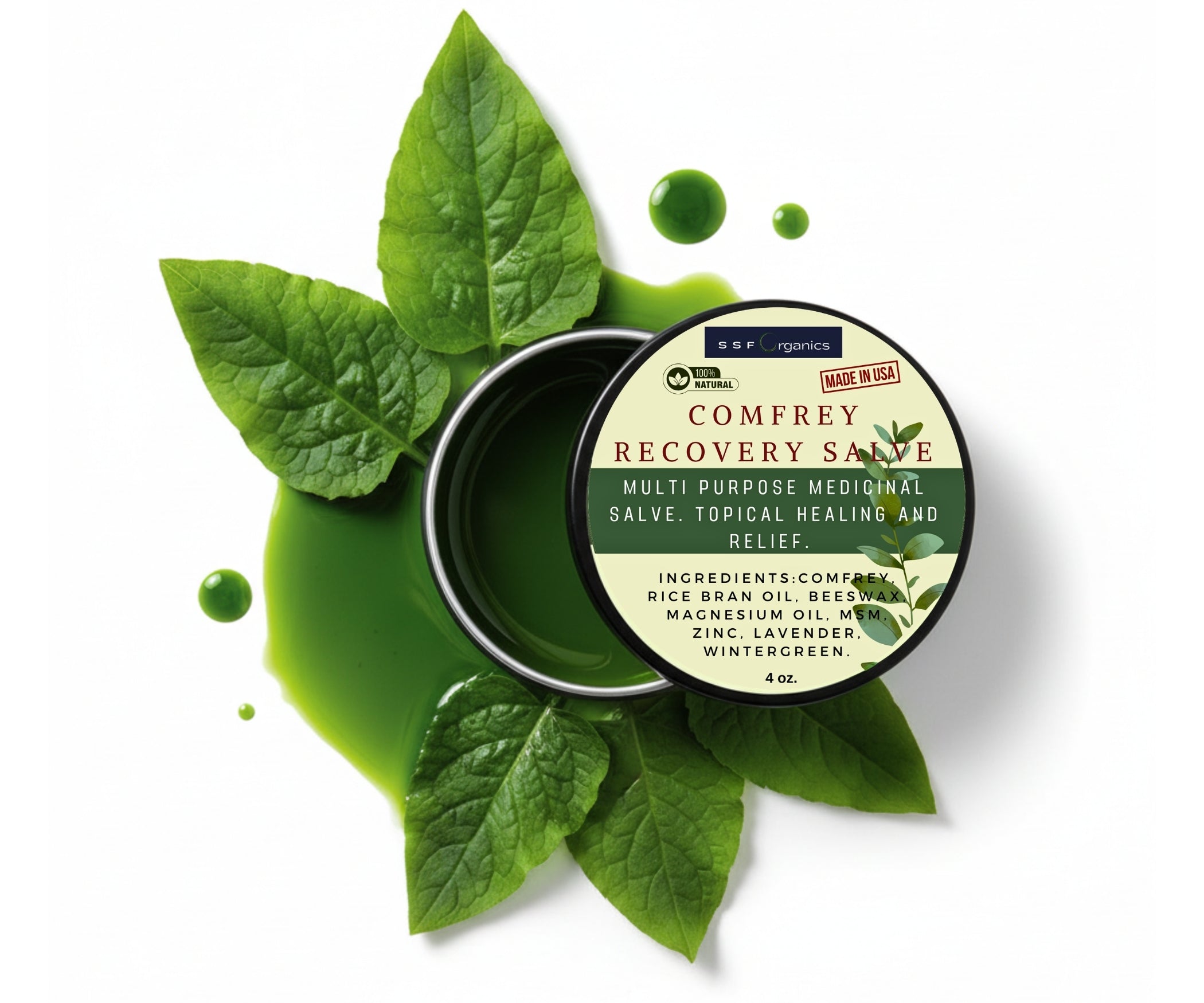 Comfrey recovery salve container with green leaves on a white background