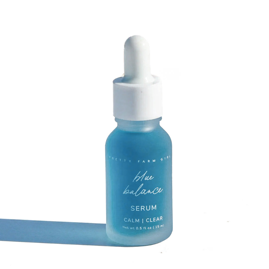 Blue Tansy essential oil serum facial bottle of serum with dropper on a white background. Two skincare products, a jar and a bottle, on a white background with a soft shadow. tallow arnica calendula tea tree pretty farm girl facial care organic soap serum and lotion