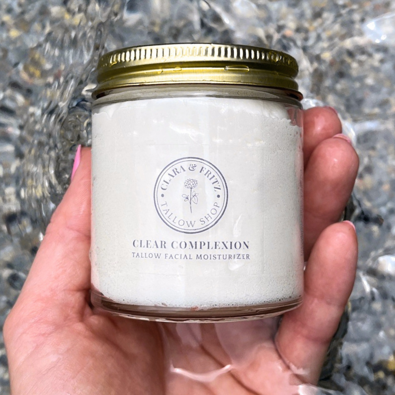Hand holding a jar of 'Clear Complexion' facial moisturizer with a gold lid. 100% grass-fed beef tallow, *extra virgin olive oil, geranium bourbon oil, pink grapefruit oil, himalayan cedarwood oil, peppermint oil, rosemary oil, roman chamomile oil; *certified organic
Clear Complexion is petroleum free, paraben-free and contains no dyes or artificial fragrances. It is safe for use on sensitive skin, and can be used daily to help prevent breakouts