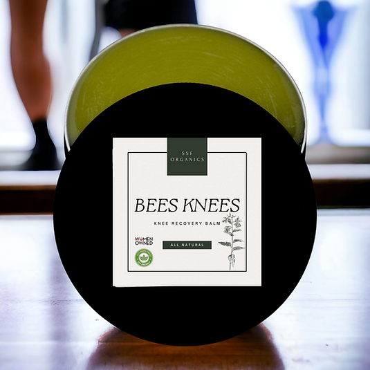 handcrafted botanical balm with nourishing ingredients. A jar of SSF Organics Bees Knees Salve, designed for knee replacement surgery. placed on a wooden surface with a label showing the product name and 'All Natural'.