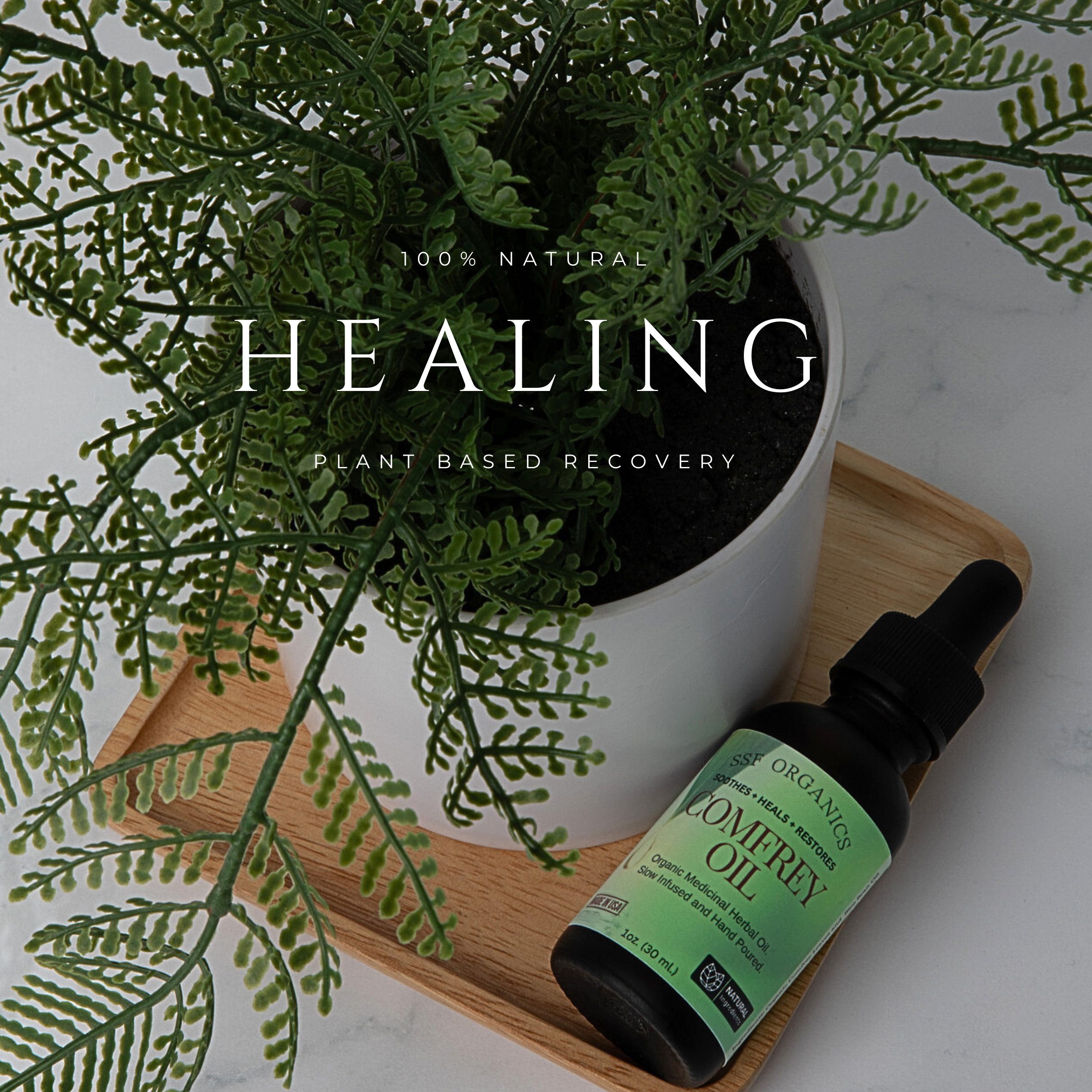 Potted plant and bottle of Comfrey Oil on a wooden tray with '100% Natural Healing' text.