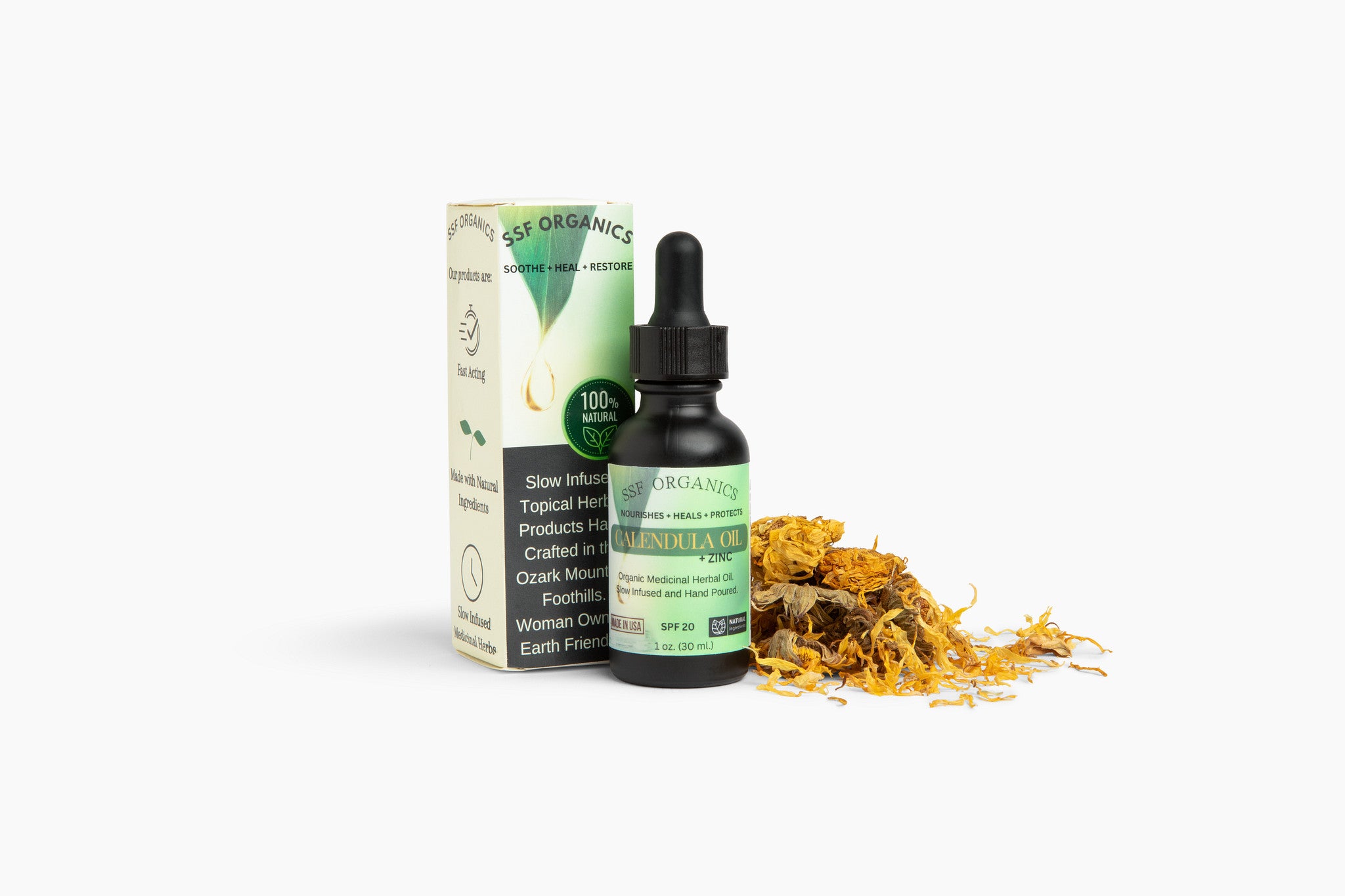 Bottle of calendula oil with packaging and dried calendula flowers on a white background