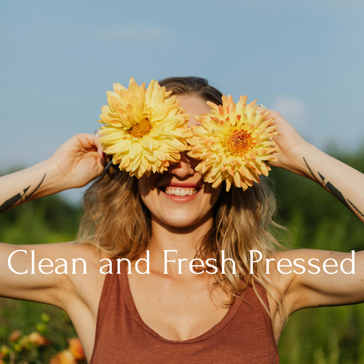 A smiling woman outdoors holding two large yellow flowers over her eyes, with the text 'Clean and Fresh Pressed' overlaid across the bottom. A glass dropper bottle of SKIN TONIC serum with a dark navy label, styled on a white background with a sliced cucumber and a purple ornamental grass flower. Not to mention tons of antioxidants. Hydrates, Reduces inflammation and accelerates healing time of acne, blemishes, and scars.
Perfect for application before Red Light Therapy Devices. Green Tea, Copper Peptides, 