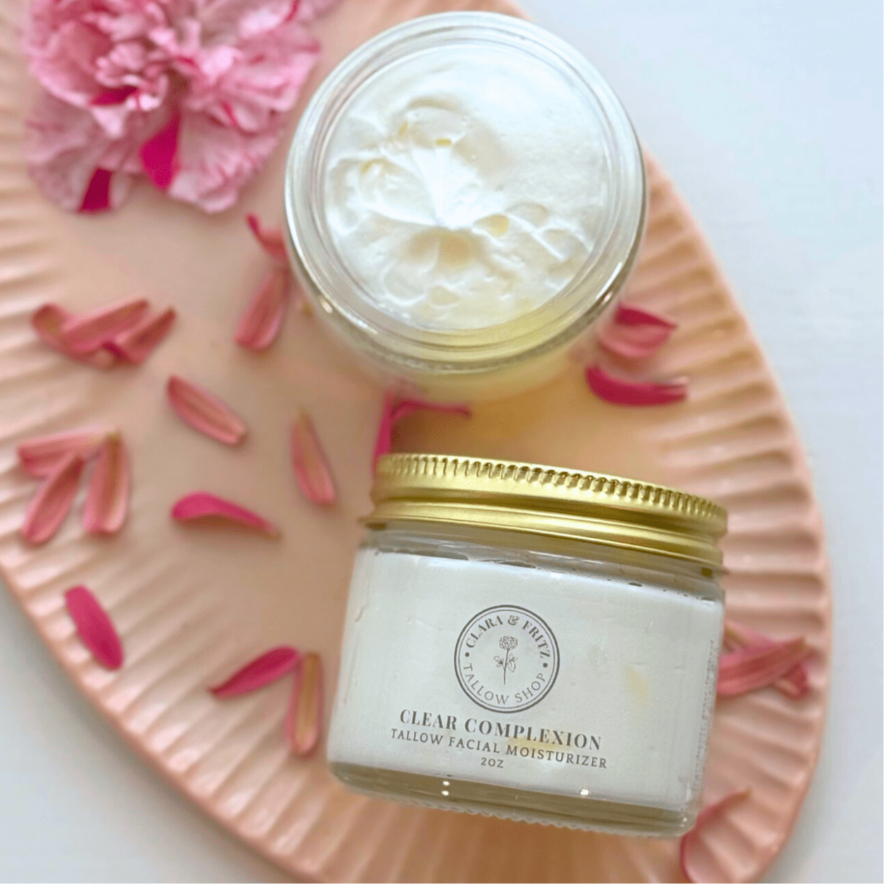 Two jars of facial moisturizer on a decorative plate with pink flowers. 100% grass-fed beef tallow, *extra virgin olive oil, geranium bourbon oil, pink grapefruit oil, himalayan cedarwood oil, peppermint oil, rosemary oil, roman chamomile oil;&nbsp;*certified organic

Clear Complexion is petroleum free, paraben-free and contains no dyes or artificial fragrances. It is safe for use on sensitive skin, and can be used daily to help prevent breakouts.&nbsp;