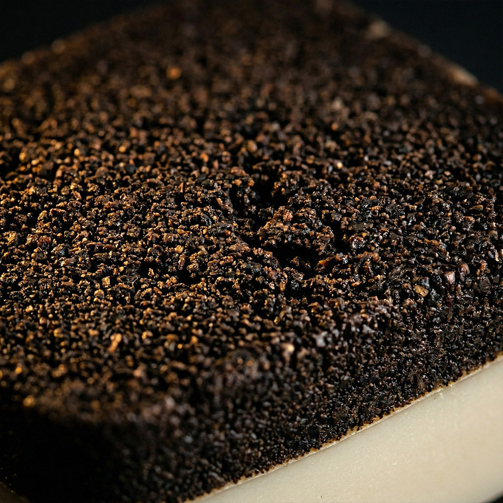 Close-up of a dark brown textured surface. Collection of 2nd Ground upcycled coffee soap bars on a stone surface with branded boxes. comfrey salve for healing arthritis workout recovery drawing salve