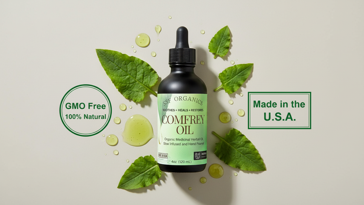 SSF Organics 4 oz Comfrey Oil bottle surrounded by green leaves and oil droplets, with natural ingredient and USA-made badges.