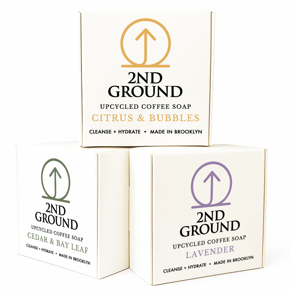 Three boxes of 2nd Ground upcycled coffee soap with different scents on a white background. Collection of 2nd Ground upcycled coffee soap bars on a stone surface with branded boxes. comfrey salve for healing arthritis workout recovery drawing salve